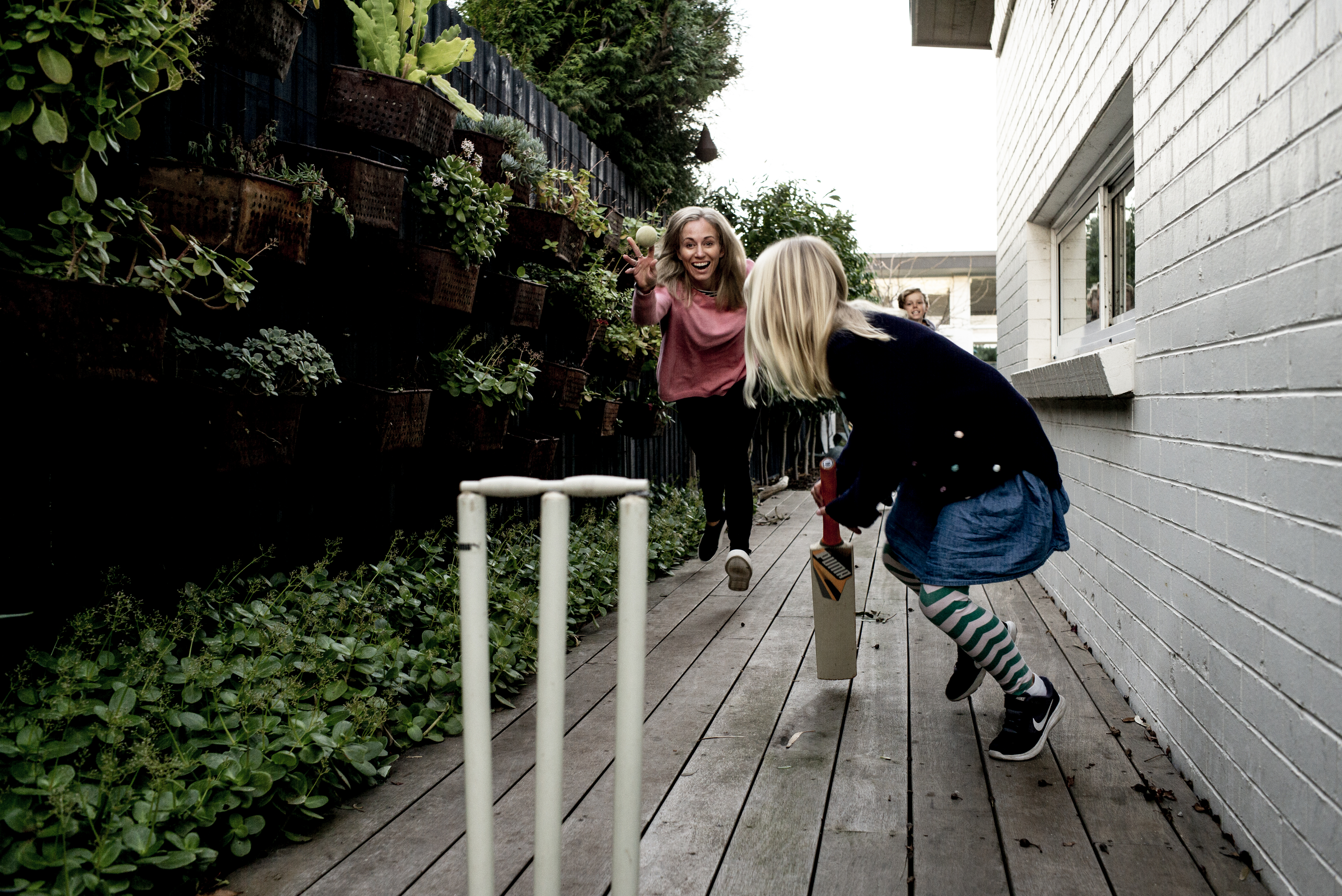 A woman and her child playing cricket