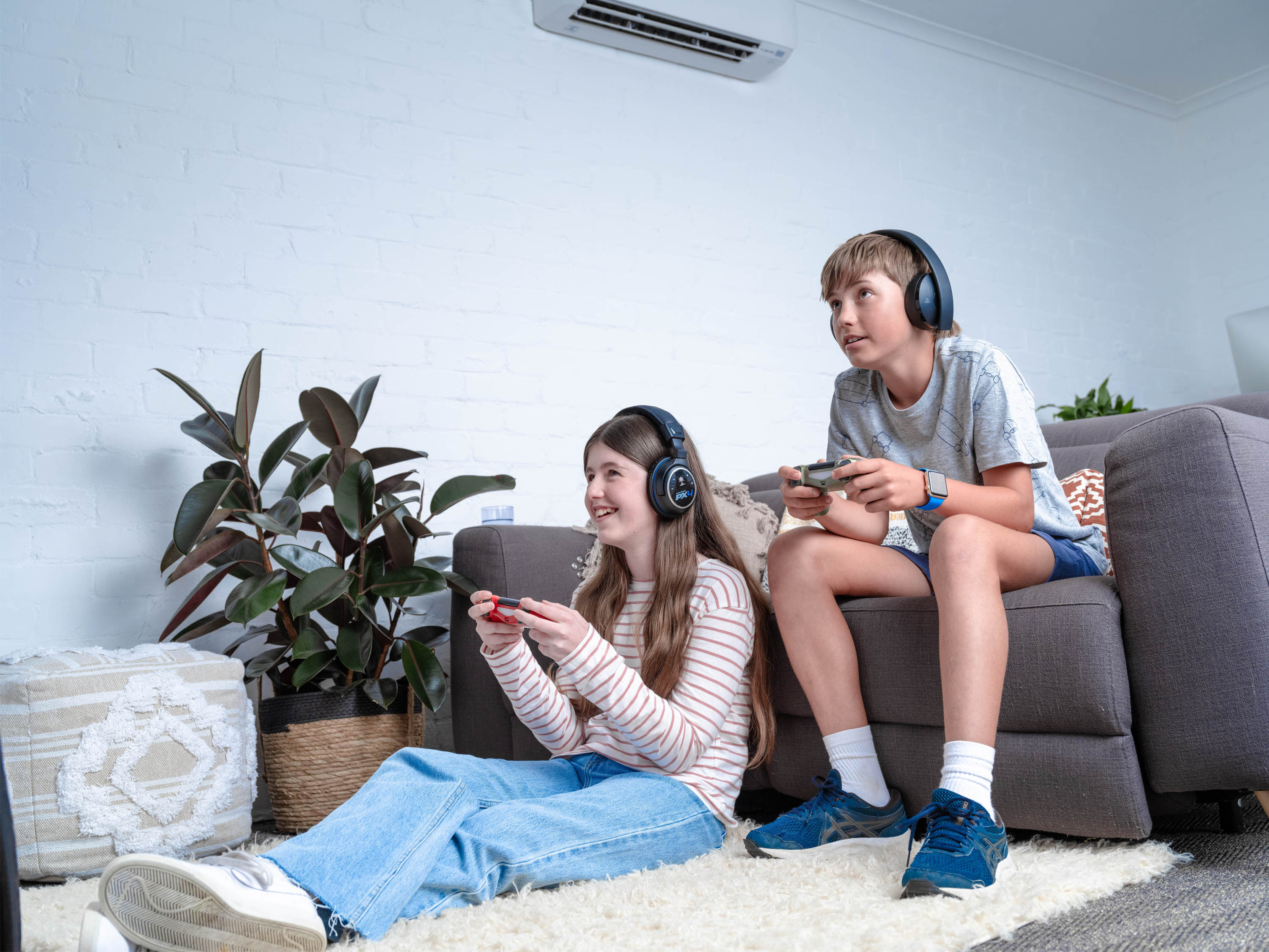 Brother and sister playing video games on couch