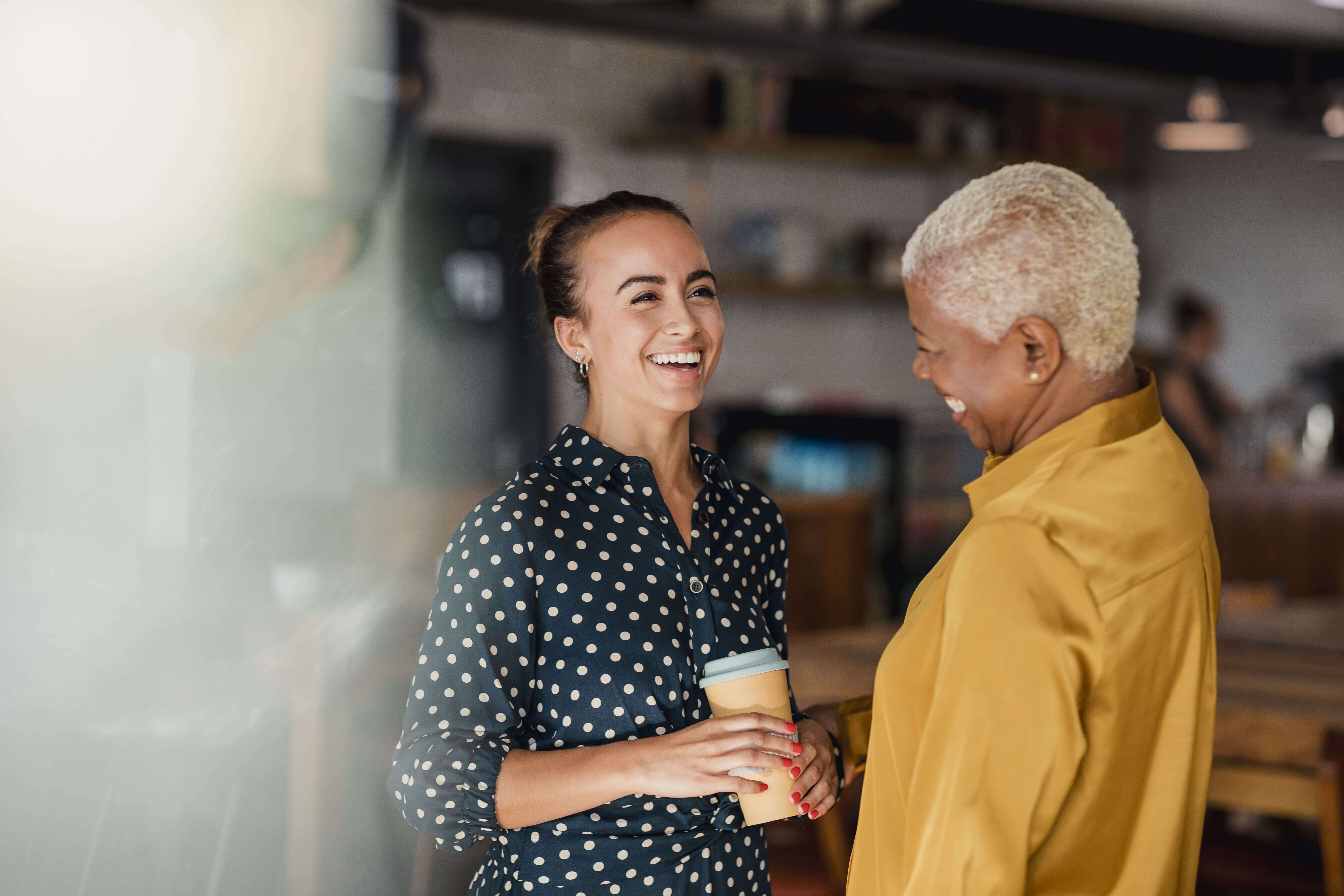 Two ladies laughing over coffee