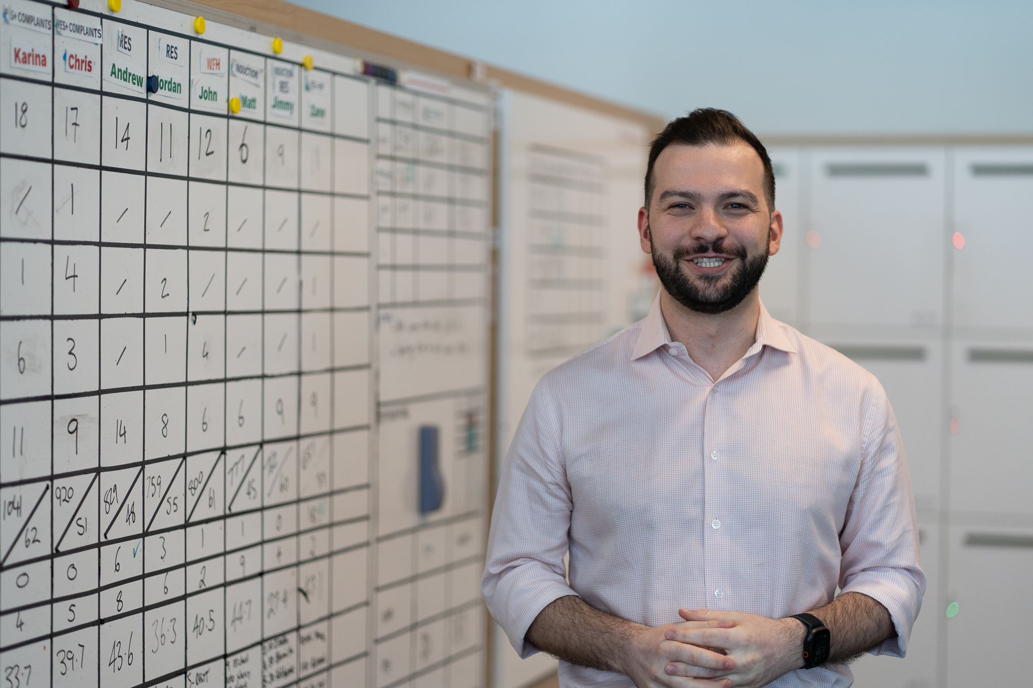 AGL team member smiling next to a whiteboard