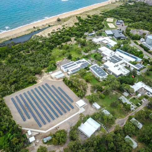Solar panel farm in lush green area by the coast