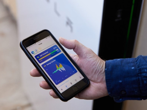 A persons’ hand holding a mobile phone showing data usage stats on a graph