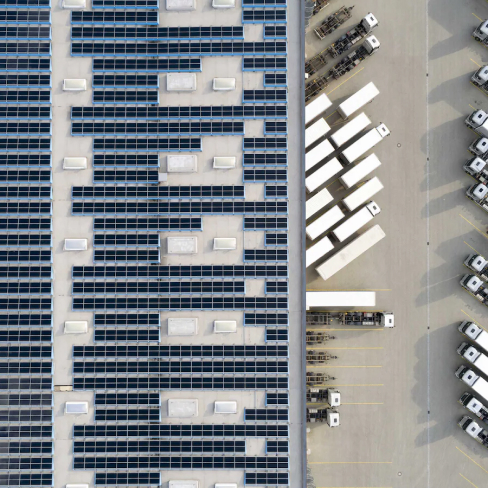 Aerial shot of a factory roof covered in solar panels
