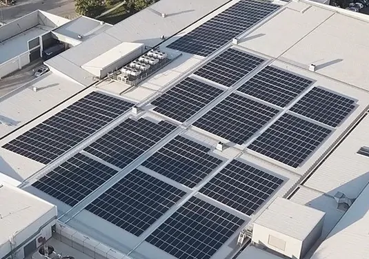 Birdseye view of large scale rooftop solar panels on aq commercial building