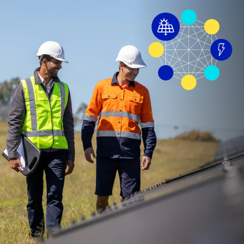 Close up of two men in high vis vests and hard hats walking through a solar farm inspecting solar panels with corner imagery
