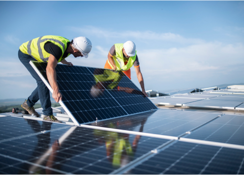 Two tradies installing a solar panel array among others at a solar farm