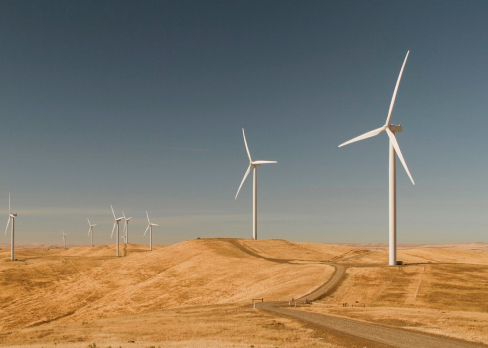 Outback scene with two windmills and a road winding through