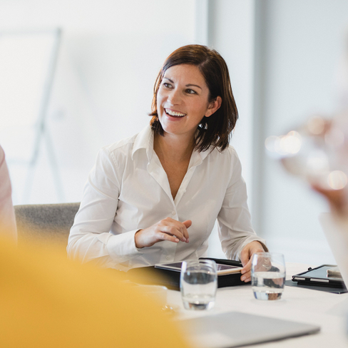 Woman smiling in an office working from a tablet
