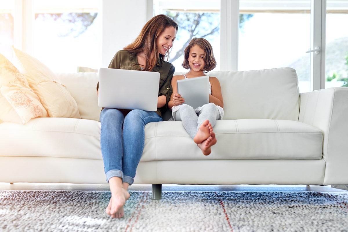 Woman and child on couch using internet