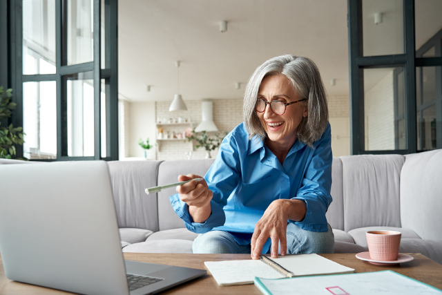 Senior woman working on her laptop from her couch