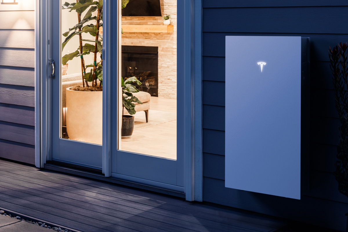 Tesla battery wall-mounted to the outside of a house.